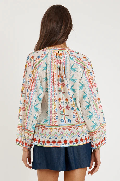Back view of the colorful Rubyyaya Biscay Shirt White showcasing vibrant prints and long sleeves.
