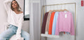 Harriett V-neck Knit displayed in various colors on hangers with a model showing a cozy look.