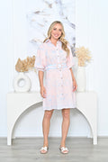 Woman wearing a Colombia Shirt Dress with a belt, featuring a pale pink base and blue print, styled for elegance.