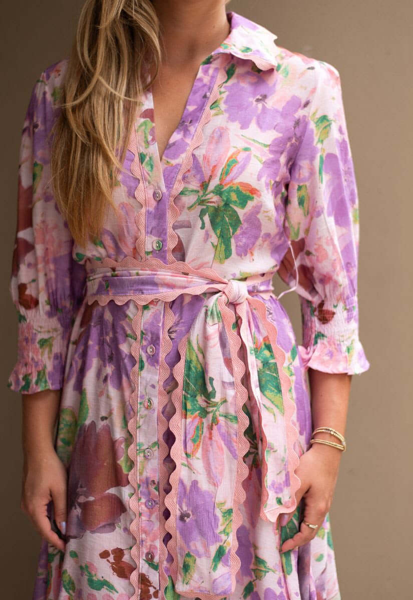 Model wearing the Mariana Floral Godet Dress, showcasing its vibrant floral patterns and elegant collar.