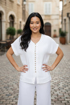 Lucy Wooden button top in white with wooden buttons and relaxed sleeves, perfect for casual or layered outfits.